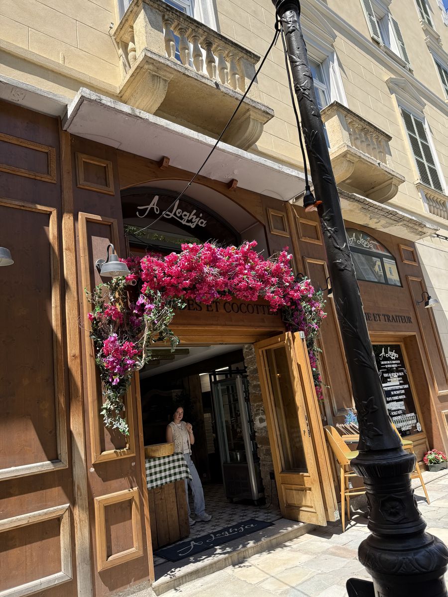 A flower-covered cafe entrance in Corsica